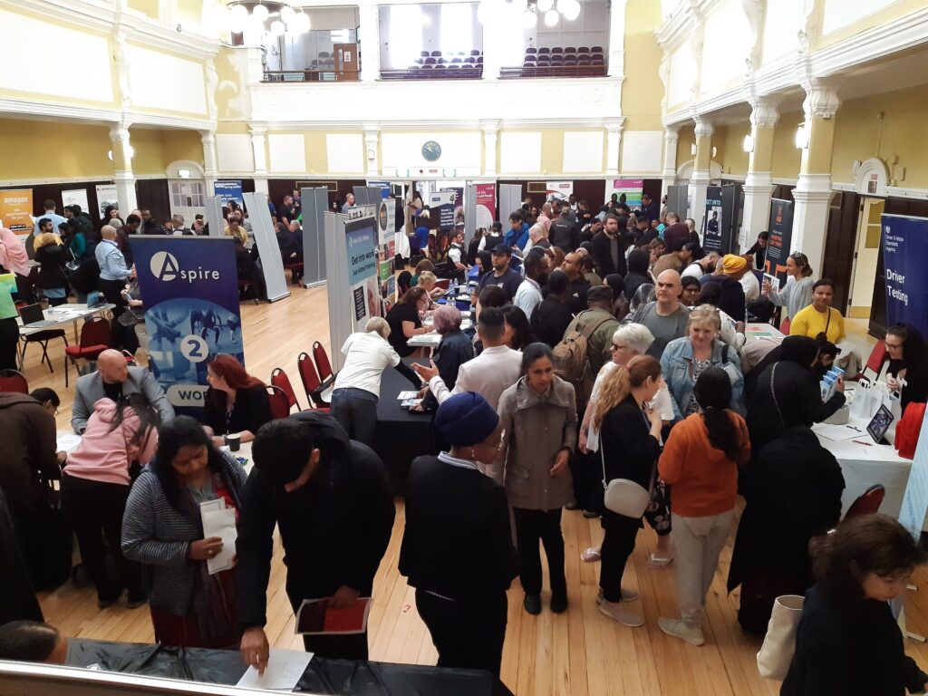 photo of the inside of Redbridge Town Hall packed with people looking at employer and training provider stands.