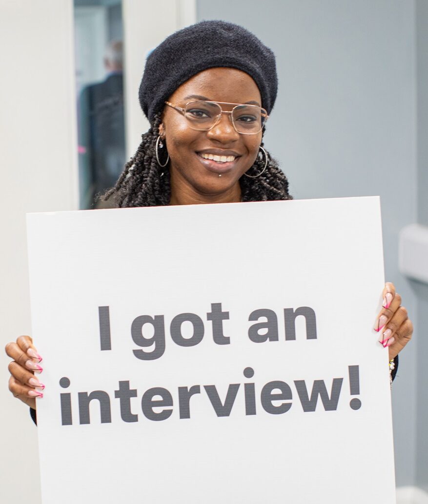 I got an interview for Programme page Woman holding sign that reads 'I got an interview!'
